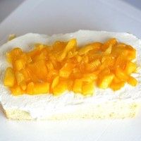 卡通汽车蛋糕,车体下面那层蛋糕抹上打发的奶油，并放上适量芒果粒。