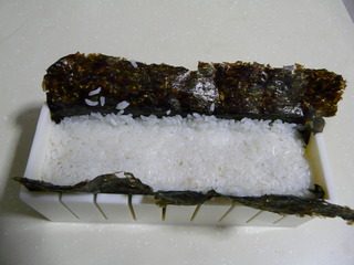 花样寿司,上面盖上米饭，并且压实。