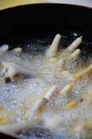 虎皮凤爪,锅中烧油，油温6成热时，将鸡爪入锅炸制（记得盖锅盖，小心不要被油溅到）；
