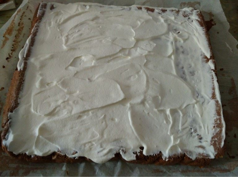 圣诞树根蛋糕,如图将淡奶油抹至蛋糕片上（一边厚点另一边薄薄一层即可）卷好定型