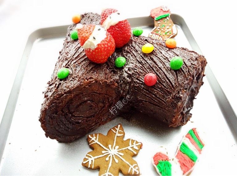 圣诞树根蛋糕,如图然后用草莓水果和糖果装饰，洒点糖粉装饰即可