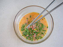 虾仁火腿鸡蛋饼,鸡蛋磕入碗里，加入少许盐和胡椒粉搅拌均匀