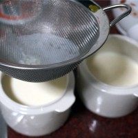 蜜豆双皮奶,用滤网将奶过滤到小炖盅里。