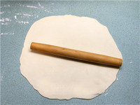 京都肉饼,案板上洒干粉，将1/2面团擀成约2-3mm厚大圆饼。