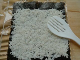花朵寿司,将米饭平铺在紫菜上，薄薄的一层。
