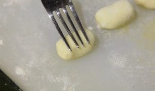 泡菜意大利面疙瘩,用手搓揉光滑，并用食品叉轻压出纹理即成意大利面疙瘩。把做好的面疙瘩放在一个撒有面粉的托盘上，每块之间留出空间，以防止面疙瘩粘在一起。