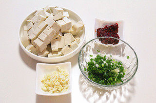 麻婆豆腐,将豆腐切成小块、蒜切末、香葱切碎、郫县豆瓣酱剁碎备用。