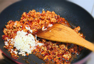 麻婆豆腐,放入豆瓣酱和辣椒面煸炒出红油，然后再放入蒜末煸炒出香味。