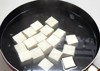 焦溜豆腐,锅内加盐1/2大匙煮开，放入豆腐块煮至水再开捞起沥净水。
