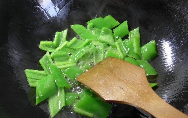 尖椒炒花螺,在锅中加入油烧热，下入切好的尖椒翻炒翻炒至熟。