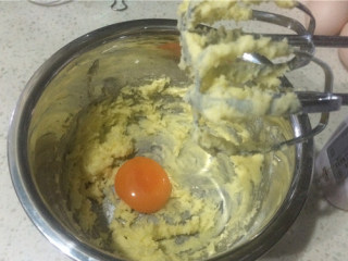 蛋黄纽扣小饼干,加入蛋黄，用电动打蛋器打至充分融合