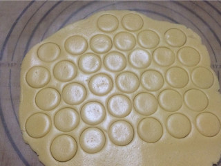 蛋黄纽扣小饼干,将面团放硅胶垫上用擀面杖擀成约3mm的面片。用小圆模或大号裱花嘴口按压出圆形