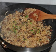 香菇肉丁油饭,转大火不停翻炒至米饭和所有材料均匀，并且饭粒干爽，撒葱花拌匀即可出锅