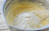 快手甜甜圈（烤箱版）,泡打和低筋粉混合过筛后，分五次加入黄油糊中拌匀。