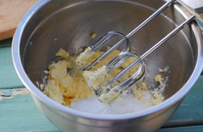 樱花曲奇,用电动打蛋器将黄油稍微打顺滑，然后加入糖粉和盐。