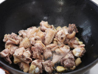 板栗烧鸡 ,油锅七分热，放入姜片、蒜头倒入锅中爆香；再放入鸡块煸炒至肉色微微泛黄。