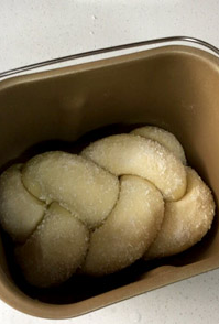 椰蓉麻花辫子面包,面包桶内的搅拌棒拿掉，然后把编好的麻花辫细的两头弯到底下，放回面包桶，