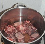 红焖牛尾,牛尾用流动的水冲泡干净血水后 ，放大锅内，注入没过牛尾的清水，开盖大火煮