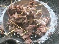 麻辣牙签牛肉,锅内倒入足量油，大火加热至7成热后，放入串好的牛肉高温炸半分钟后捞出。