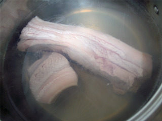 蒜泥白肉,煮锅加入适量水烧开后将五花肉绰水后捞出。