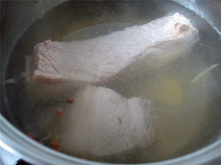 蒜泥白肉,洗净锅后加入适量水烧开后放入五花肉、姜、料酒及花椒粒。
