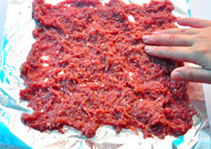 蜜汁猪肉脯,将锡纸平铺在烤盘背面，锡纸表面涂少许油，将1/2份量的肉糜放在锡纸上用手推展开。
