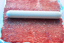 蜜汁猪肉脯,在肉糜的表面铺上一张保鲜膜，用擀面杖将肉糜擀成薄厚均匀的片状。