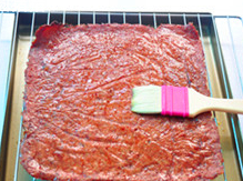蜜汁猪肉脯,将烤好的肉块，取出两面刷上蜂蜜水，放置在烤网上。