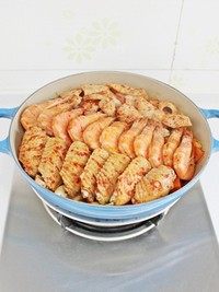 三汁焖锅,盖上锅盖，中火焖15分钟至大虾鱿鱼鸡翅变色成熟。