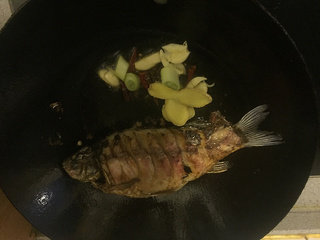 红烧鲫鱼,两面都炸焦黄后，到出多余的油，放入花椒大料，红辣椒，葱姜蒜，超出香味。