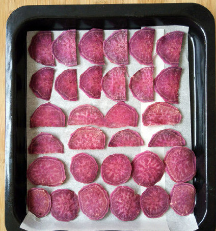 香脆烤紫薯片,把油纸或锡纸铺在烤盘上，然后将紫薯片摆开。