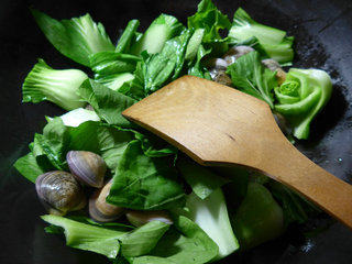 青菜圆蛤汤,烧锅倒油烧热，下入切好的青菜和清洗好的圆蛤翻炒一下。