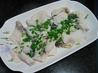 椒麻水煮鱼片,煮好的鱼片盛入盘中，撒上葱花备用。