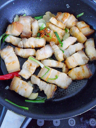 毛氏红烧肉,炒香后把煎好的五花肉放入锅内翻炒下后，加入料酒10g，炒匀。