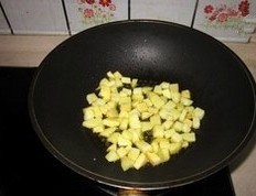 土豆培根焗饭,锅中倒油（比平时炒菜多一些），先把土豆丁中小火煸至边缘略焦；