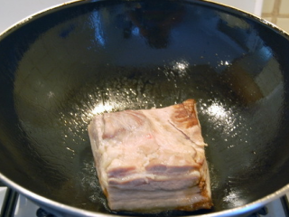 咸烧白,炒锅或者平底锅内放入少量的油，将肉的肉皮朝下放入锅中炸至肉皮呈棕红色时捞起。