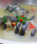 大蒜泡椒焖鲇鱼,起锅时上面放一些青色杭椒，小米辣点缀，鱼汤的酸辣味更浓厚。