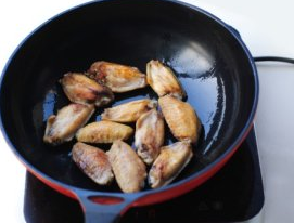 可乐鸡翅,锅里倒油烧热，放入鸡翅，煎到两面泛黄。
