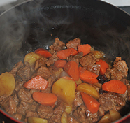 红烧土豆牛腩,将土豆、胡萝卜、洋葱倒入锅中，和牛肉放在一起炖15分钟，转大火收浓锅中汤汁，即可出锅.