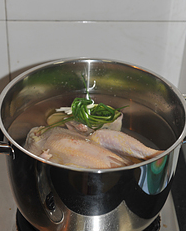 川香口水鸡,三黄鸡洗净，放入大锅中，加入冷水没过鸡、放姜片葱段和少许料酒。
