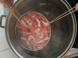 葱爆羊肉,准备好一锅开水，将羊肉片下锅中，用筷子搅散后，不要等水开，就快速捞出来备用。