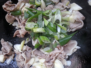 葱爆羊肉,下入葱叶，翻炒。