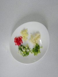 口水鸡,半棵小葱、1片姜、2瓣蒜、1棵香菜和1个泰椒分别切成末。