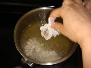 香橙双色菊花鱼,煮锅热油到放入筷子起泡然后将裹上生粉的鱼块放进去炸熟捞起沥干油份。