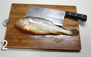 香煎黄花鱼,用利刀从鱼背部剖开。