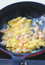 滑蛋虾仁,用锅铲迅速划圈圈将蛋炒散。
