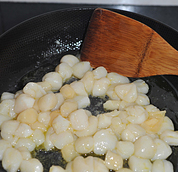 甜豆炒鲜贝,锅烧热放油，油温热的时候倒入腌制好的鲜贝，滑炒开。
