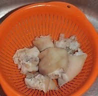 红焖猪蹄,猪蹄清洗干净，锅中放水放葱姜烧开后，放入猪蹄开着盖子煮两分钟，捞出用冷水冲降温，沥干