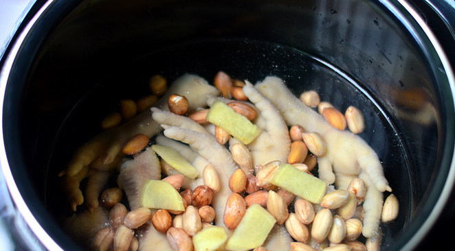 花生鸡脚汤,将焯水后的鸡脚与泡好的花生放入压力锅内胆，加入姜片，兑入1.5升水
