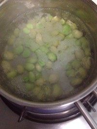 蚕豆肉丁酸菜炒笋,水烧开把蚕豆倒入汆烫一分钟捞起待用。